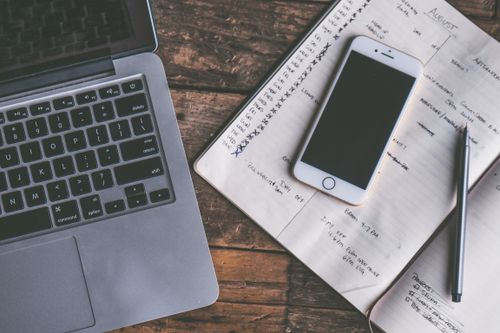 laptop, phone and notepad on the desk