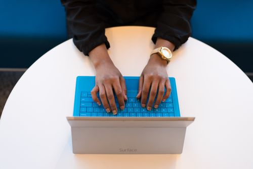 hands of person of colour on keyboard